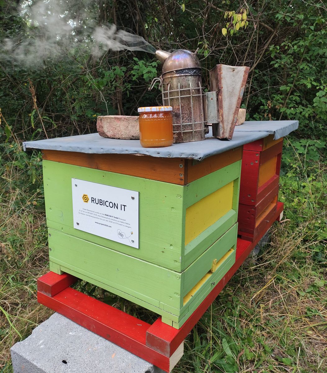 Zwei Bienenbeuten mit Honigglas und Smoker am Dach